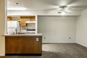 A kitchen with a white fridge and wooden cabinets at Pheasant Run Apartments, Indiana